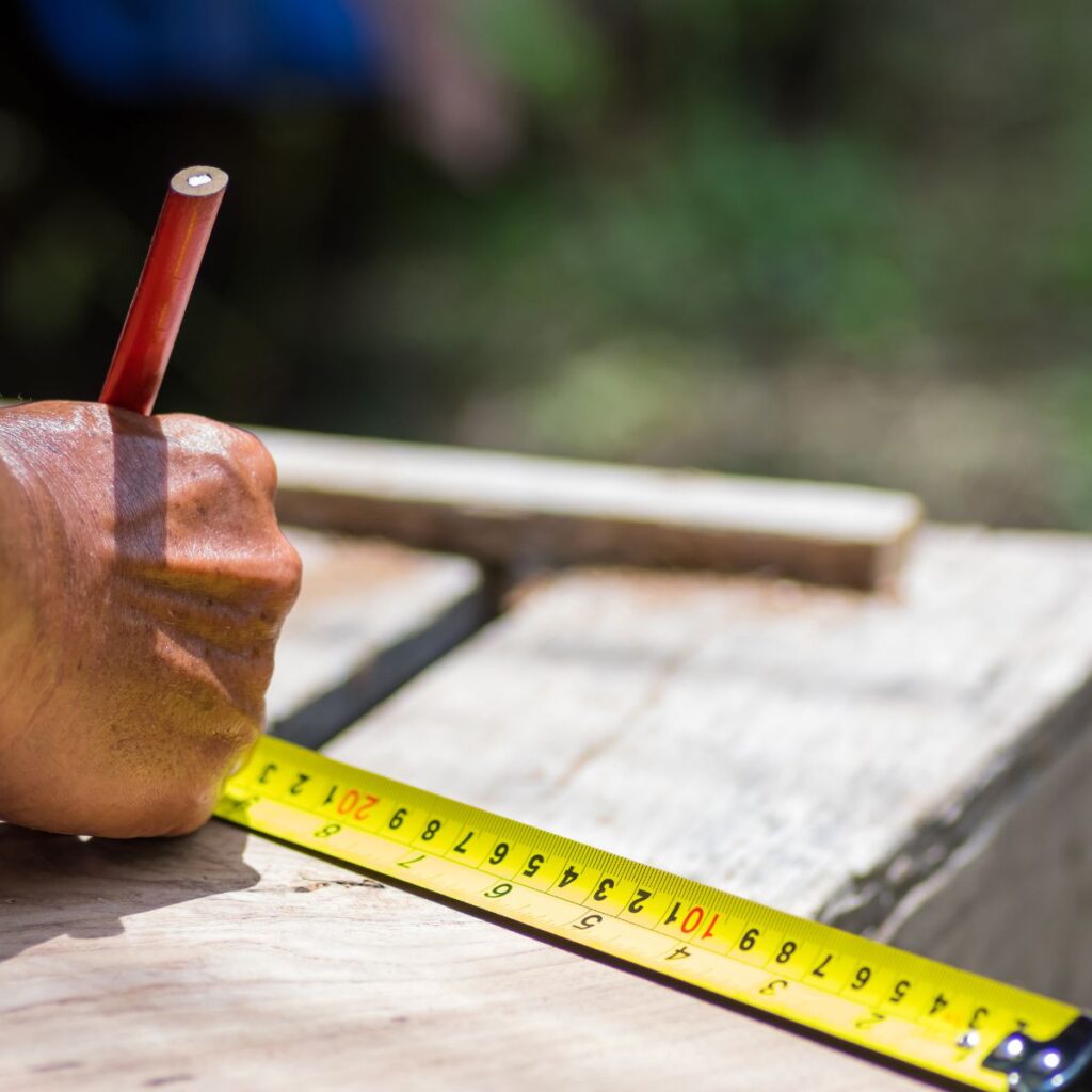 handyman measuring wood for repair job