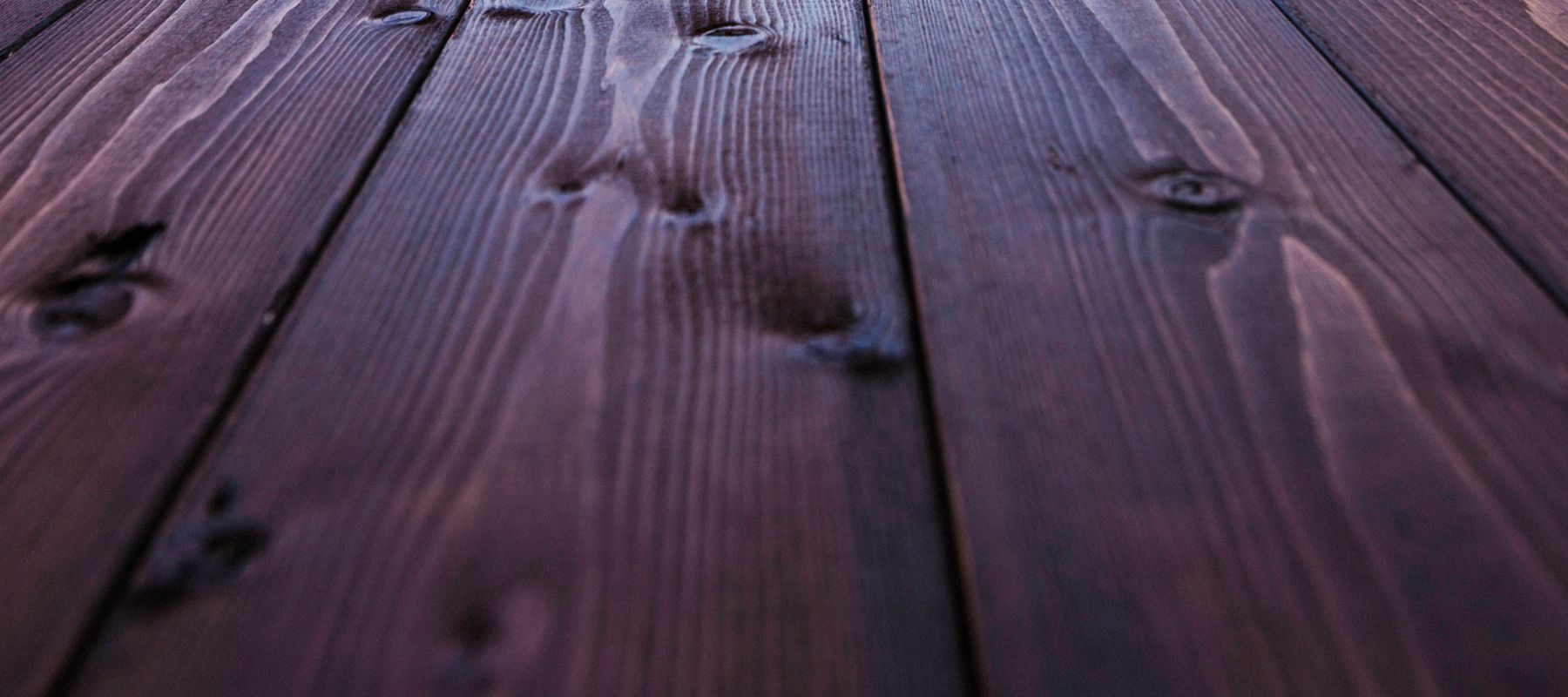 close up of fresh cherry-colored stain on a deck