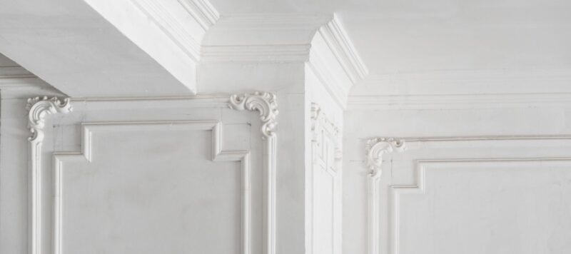 Elegant white wall with decorative molding and intricate trim details